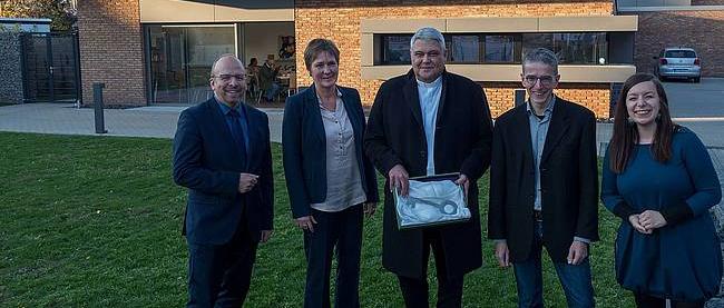 Menschen mit einem symbolischen Schlüssel feiern die Eröffnung des Bürgerzentrums