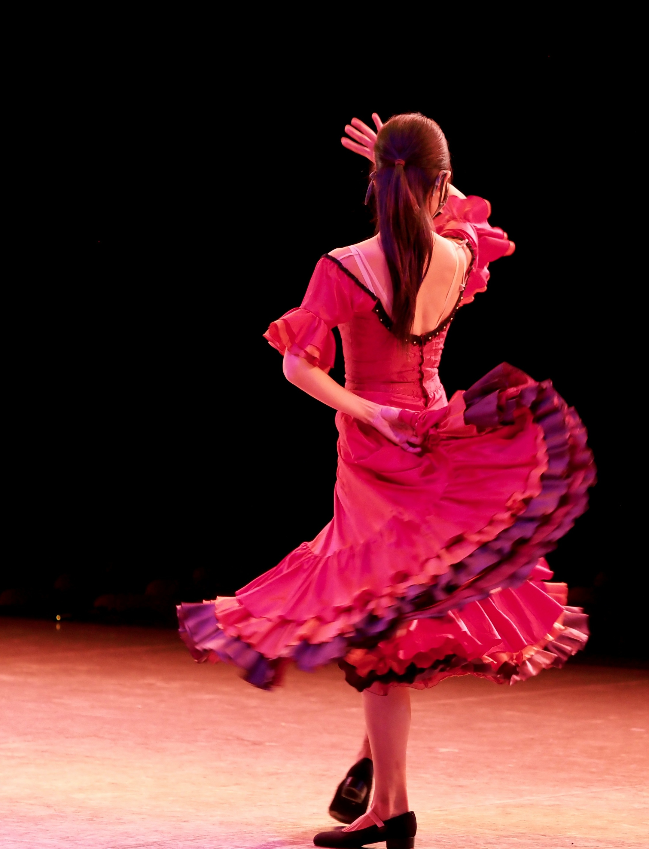 Frau im rosa Kleid tanzt auf der Bühne