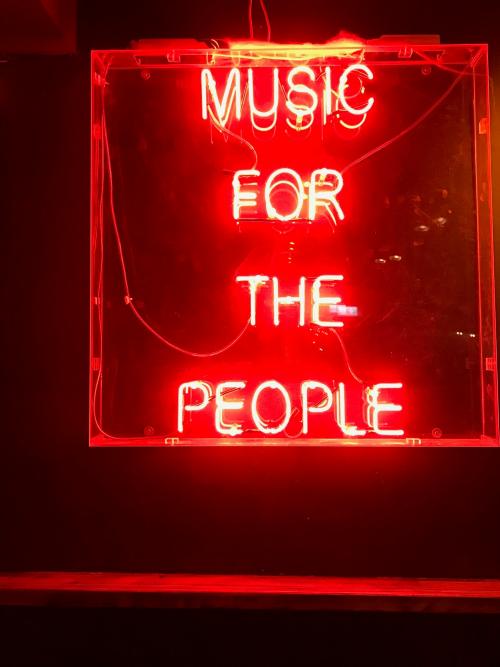 Ein Leuchtreklameschild bei Nacht mit der Aufschrift Music for the people